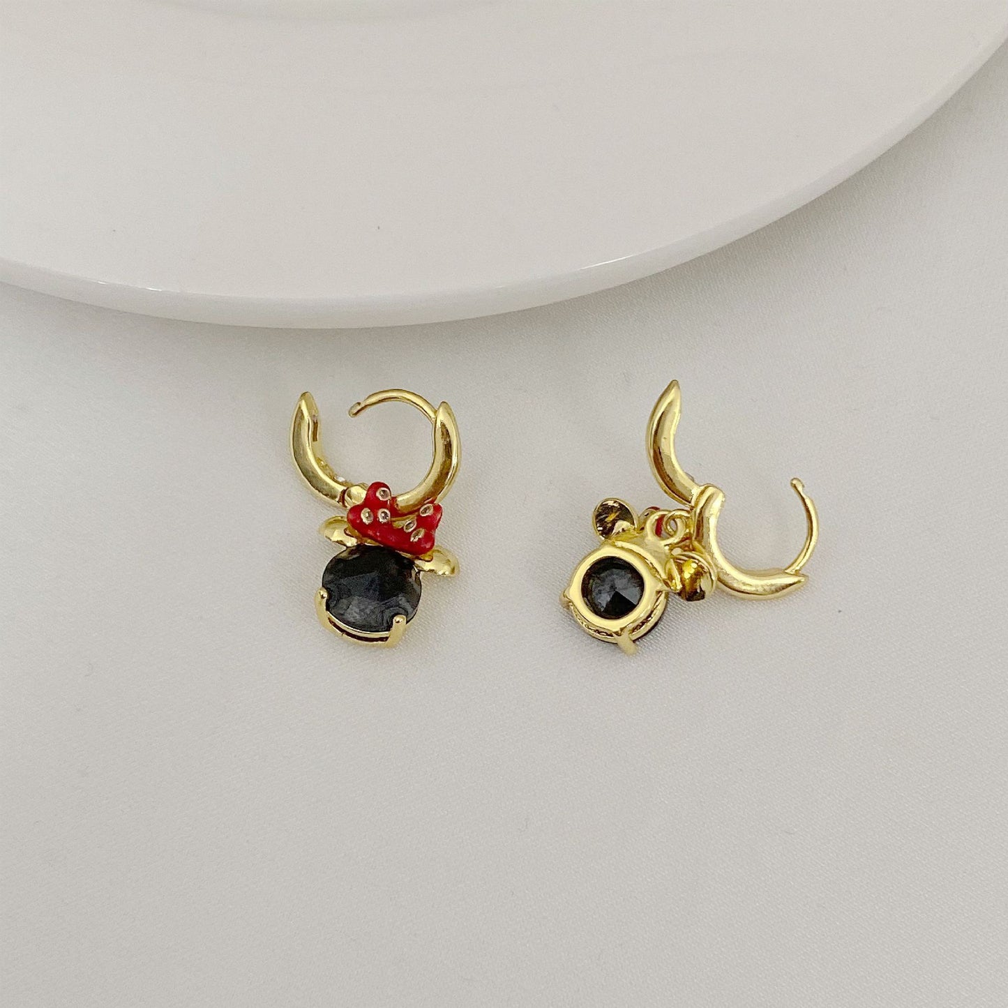 High-definition shot of the pair of earrings laid flat on pure white background, arranged symmetrically.