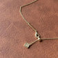 Gold necklace with a pendant on a brown leather surface