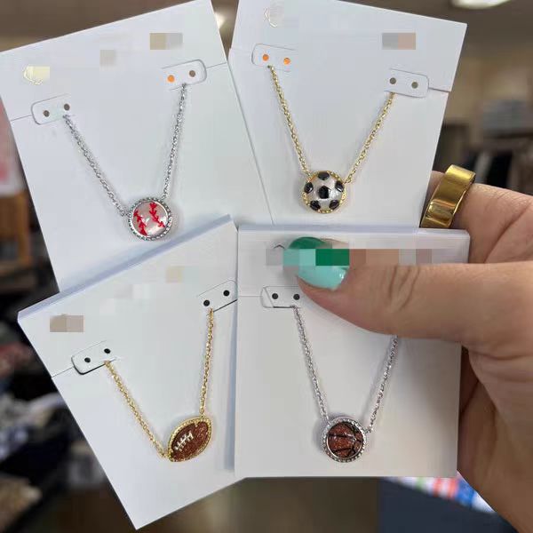Four necklaces on display cards held by a hand with a blurred background