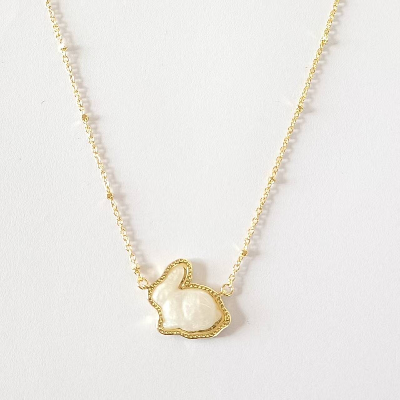 Clean, simple shot of the necklace laid flat or worn, against a plain background, clearly showing the cross pendant and chain.