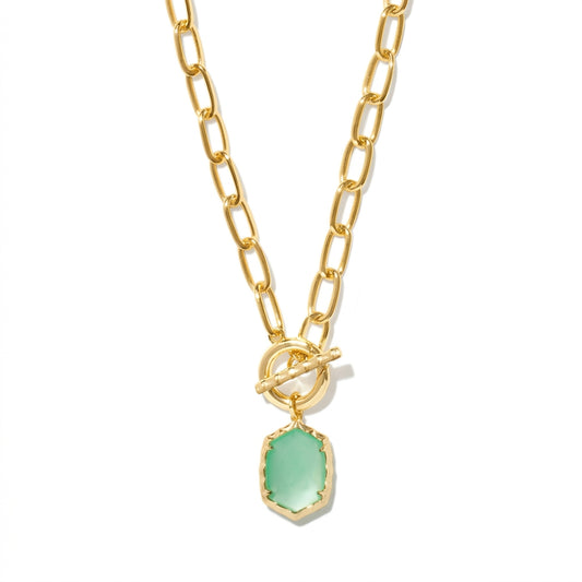 A gold chain necklace with a toggle clasp and a small hexagonal pendant featuring a light green stone, shown on a clean white background.