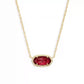 Gold necklace with a red gemstone pendant on a white background