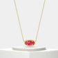 Gold necklace with a red gemstone on a white background