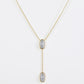 Clean shot of the necklace laid flat to show the Y-shape and pendant detail against a neutral background