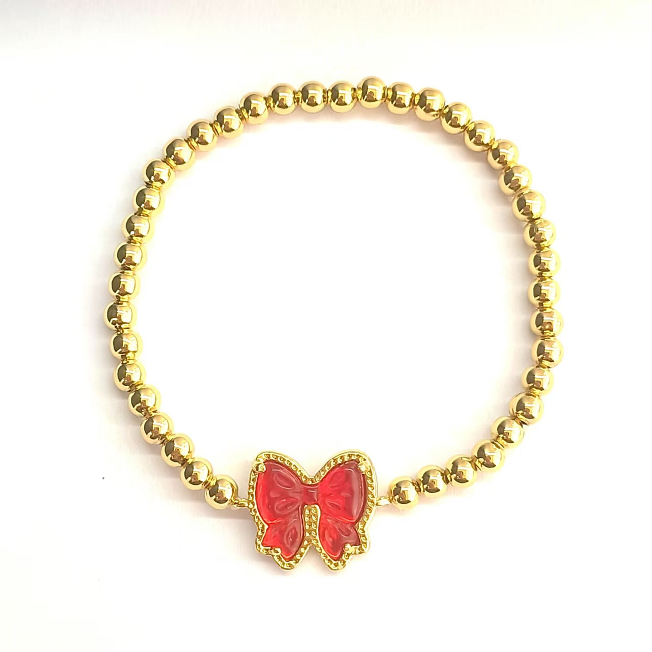  Clean shot of the bracelet laid flat or slightly curved, against a neutral background, clearly showing the bow charm and stretch band.