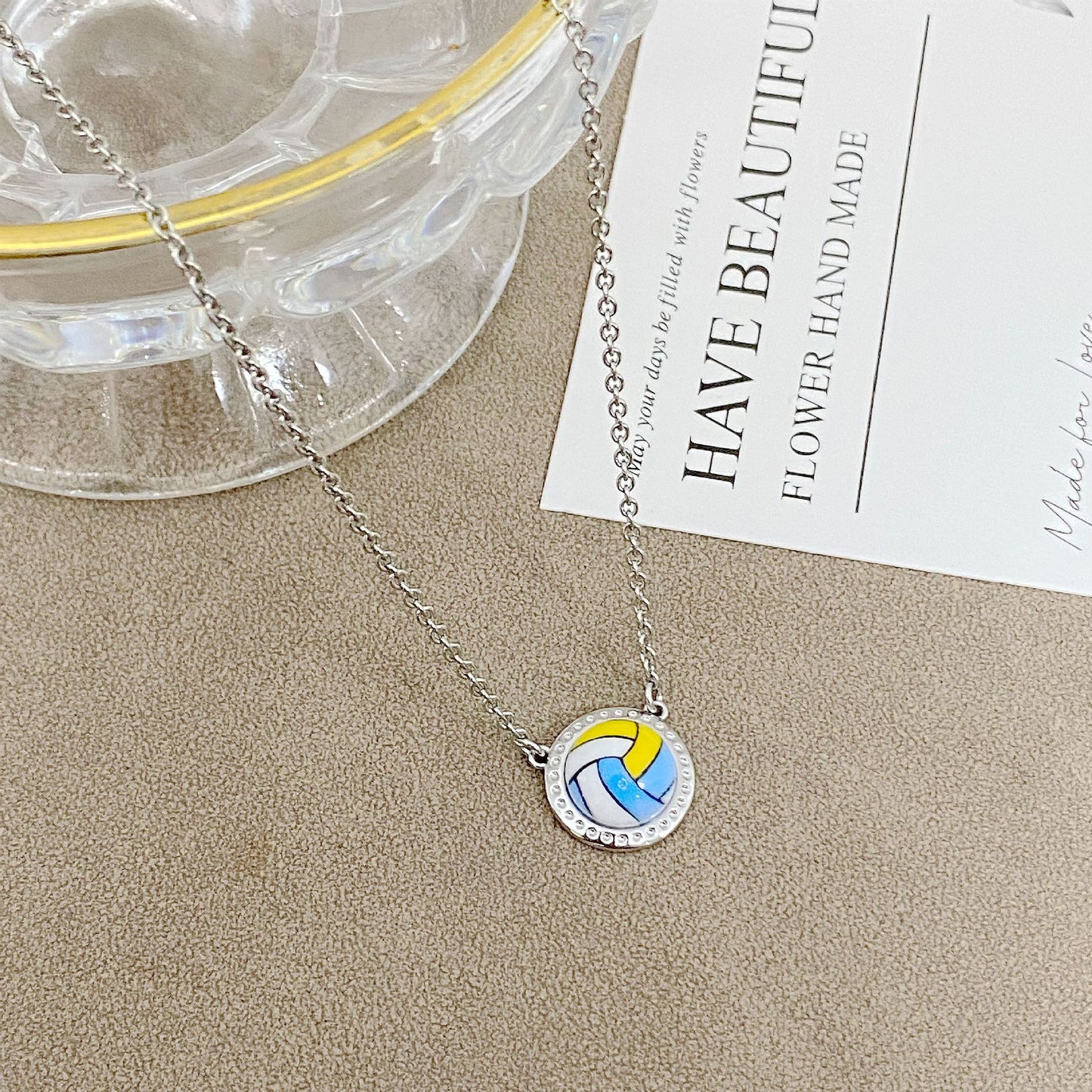 ZERRA Kendra Scott gold short pendant necklace featuring a volleyball-shaped charm on a delicate chain.