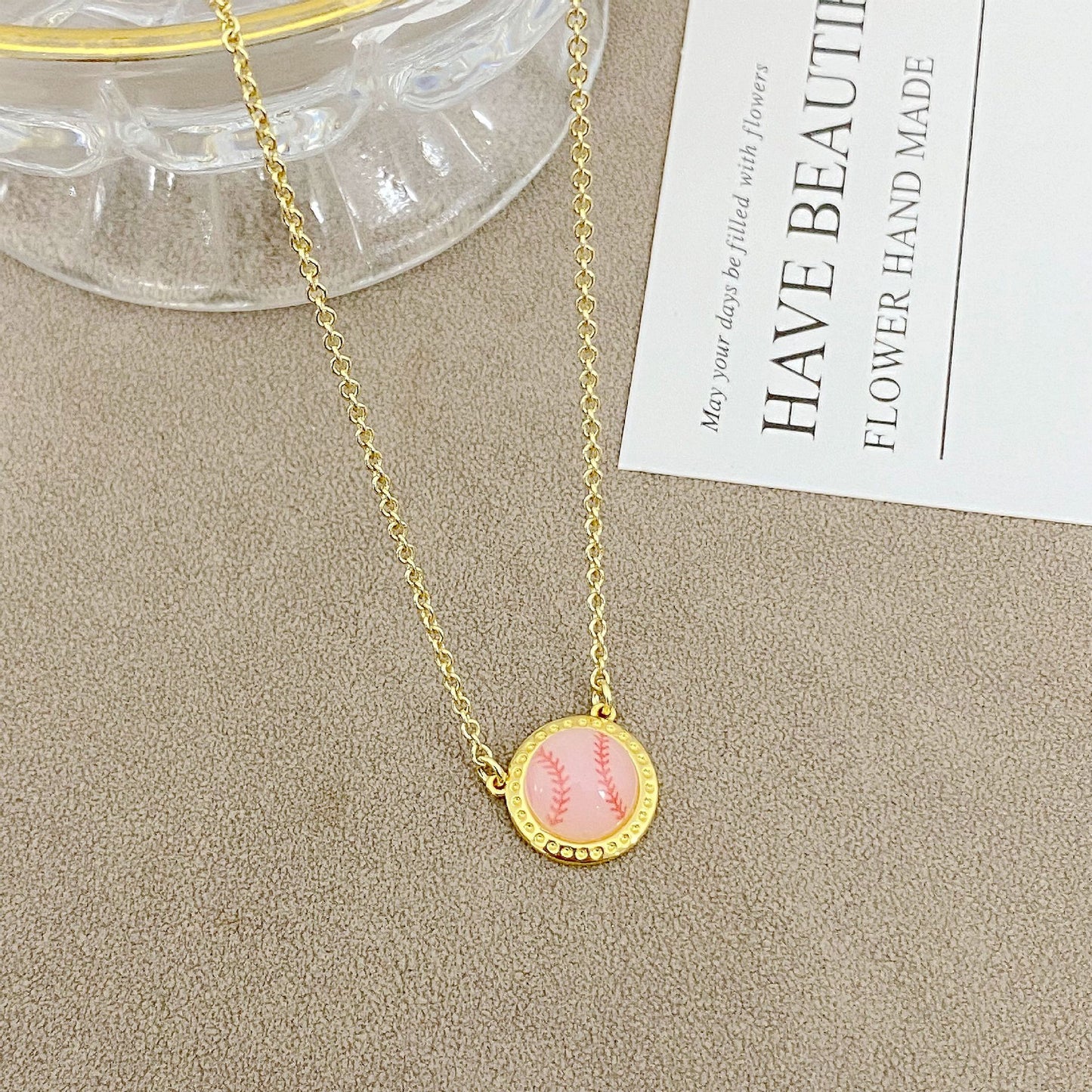 ZERRA Kendra Scott gold volleyball pendant necklace with short chain, featuring a sleek, elegant jewelry design.