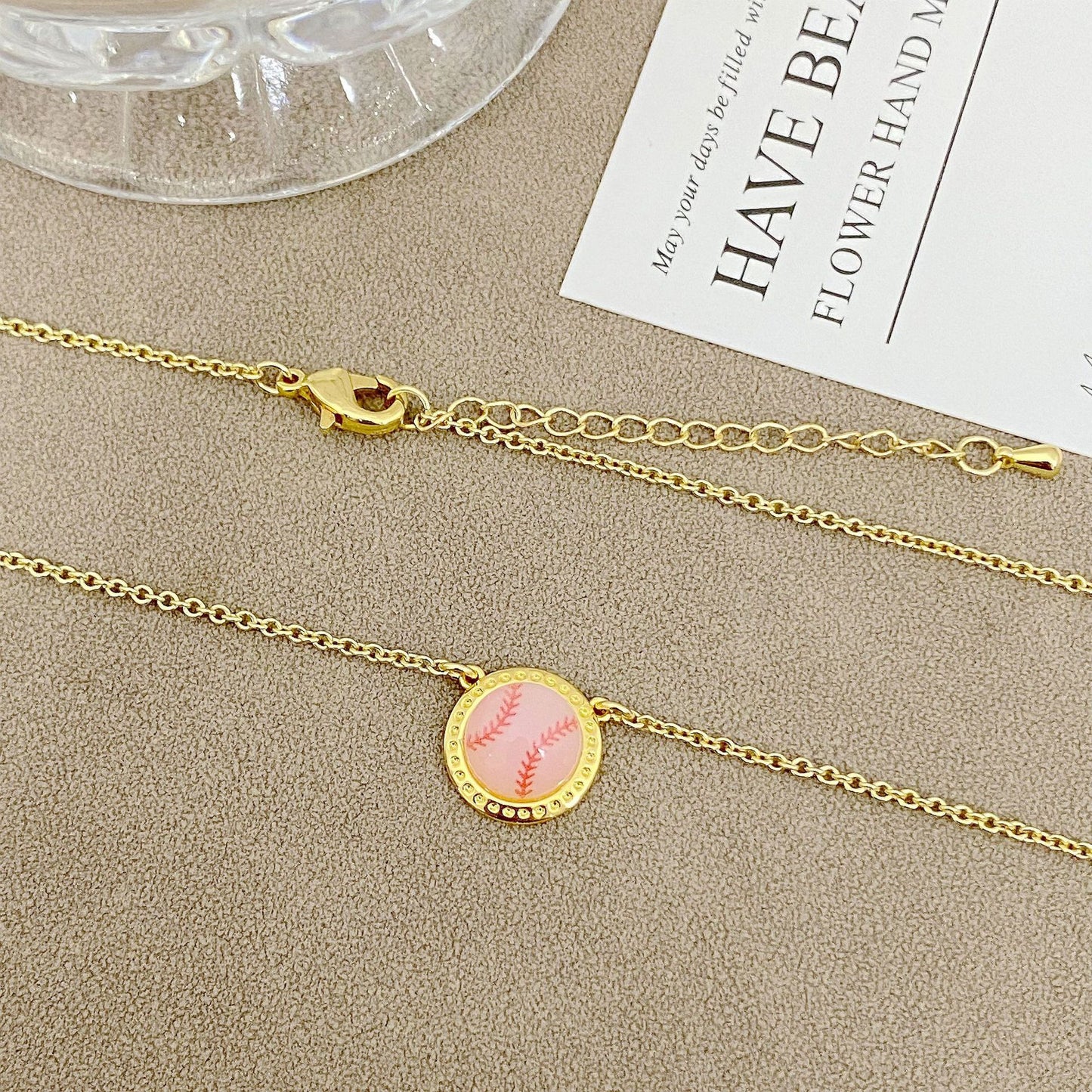 ZERRA Kendra Scott gold short pendant necklace featuring a volleyball-shaped charm on a delicate chain.