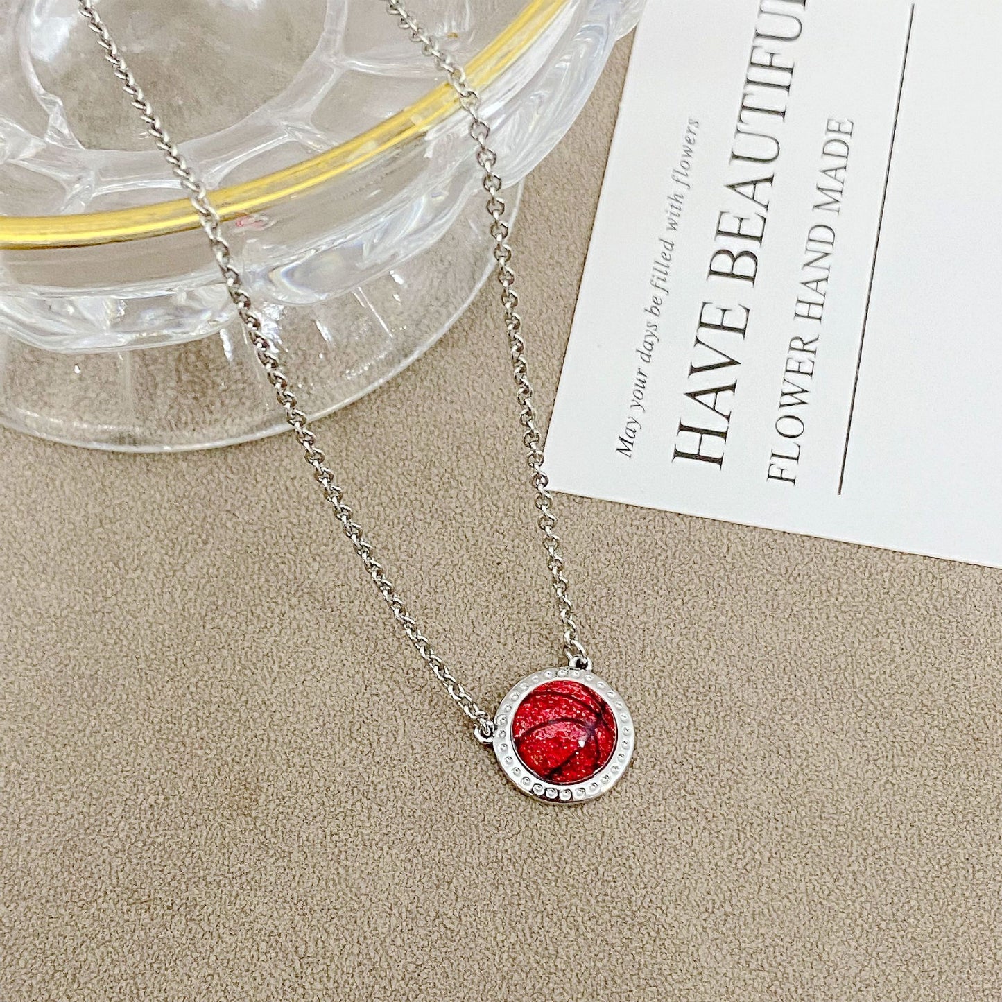 ZERRA Kendra Scott gold volleyball short pendant necklace with delicate chain and small round pendant on a white background.