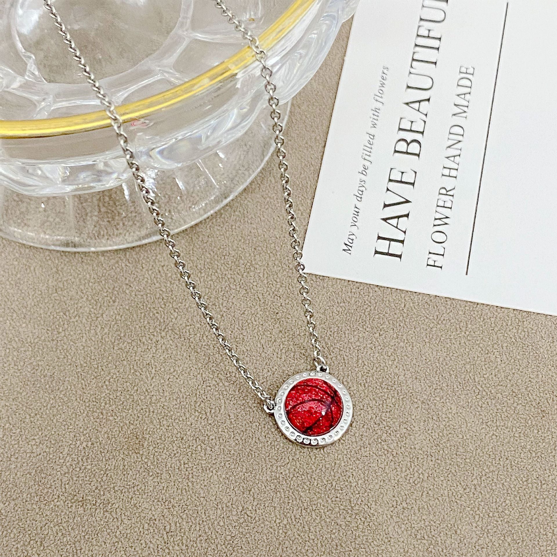 ZERRA Kendra Scott gold volleyball short pendant necklace with delicate chain and small round pendant on a white background.