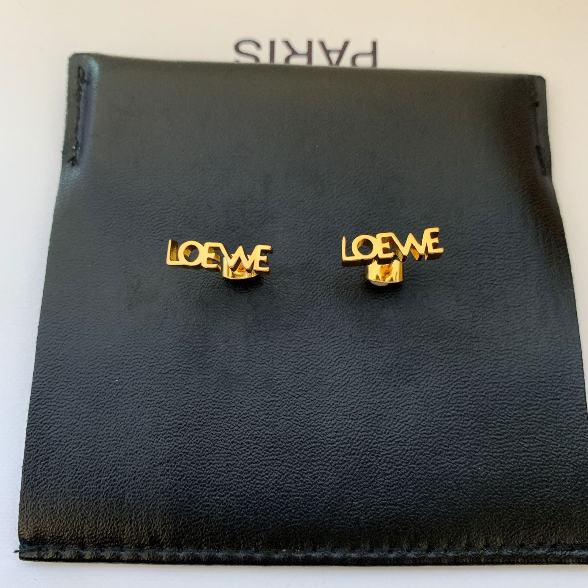  Powerful, focused shot of the single earring against a clean background, emphasizing its graphic design.