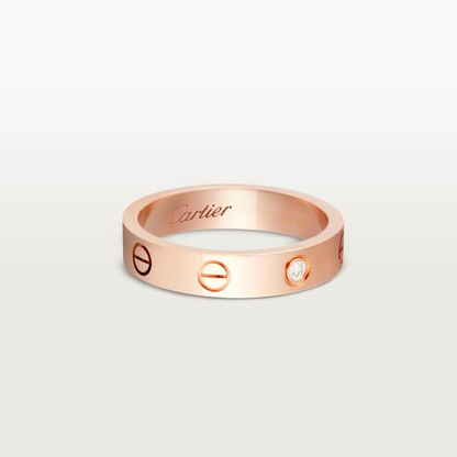Rose gold Cartier ring with a diamond on a light gray background