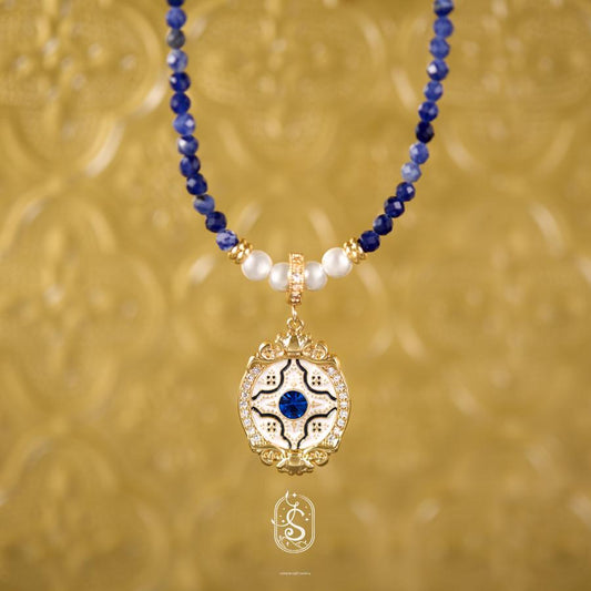 Necklace with blue and white beads and a gold pendant on a gold background