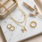 Focus on the precision of the stone setting along the curves and edges of the letter, the facet brilliance, and the bail attachment.