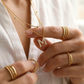Include close-up shots showing the double "M" pendants at different lengths against the collarbone and wider shots showing the complete layered look.