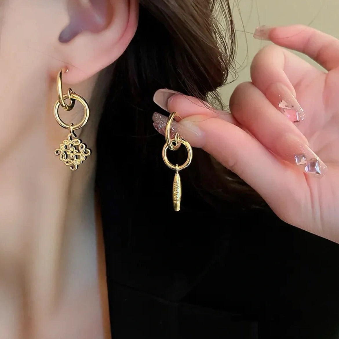 Macro shot focused on the two earrings together, highlighting the contrast in design.