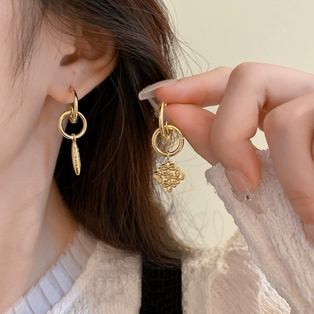 Macro shot focused on the two earrings together, highlighting the contrast in design.