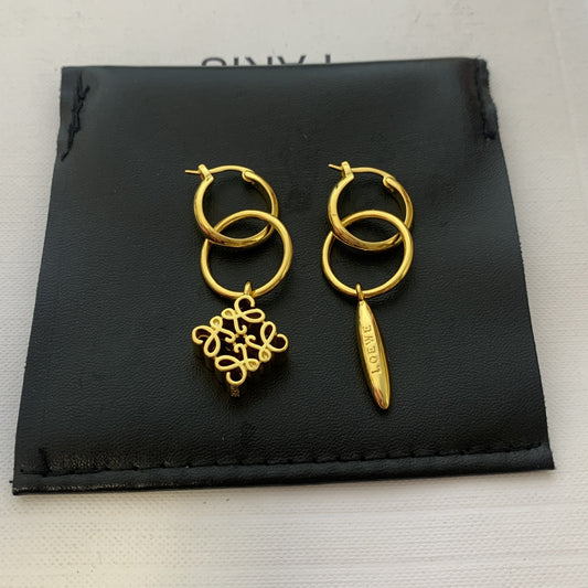 Clean shot of both earrings side-by-side on a plain background, clearly displaying the asymmetric design—one solid, one negative space.