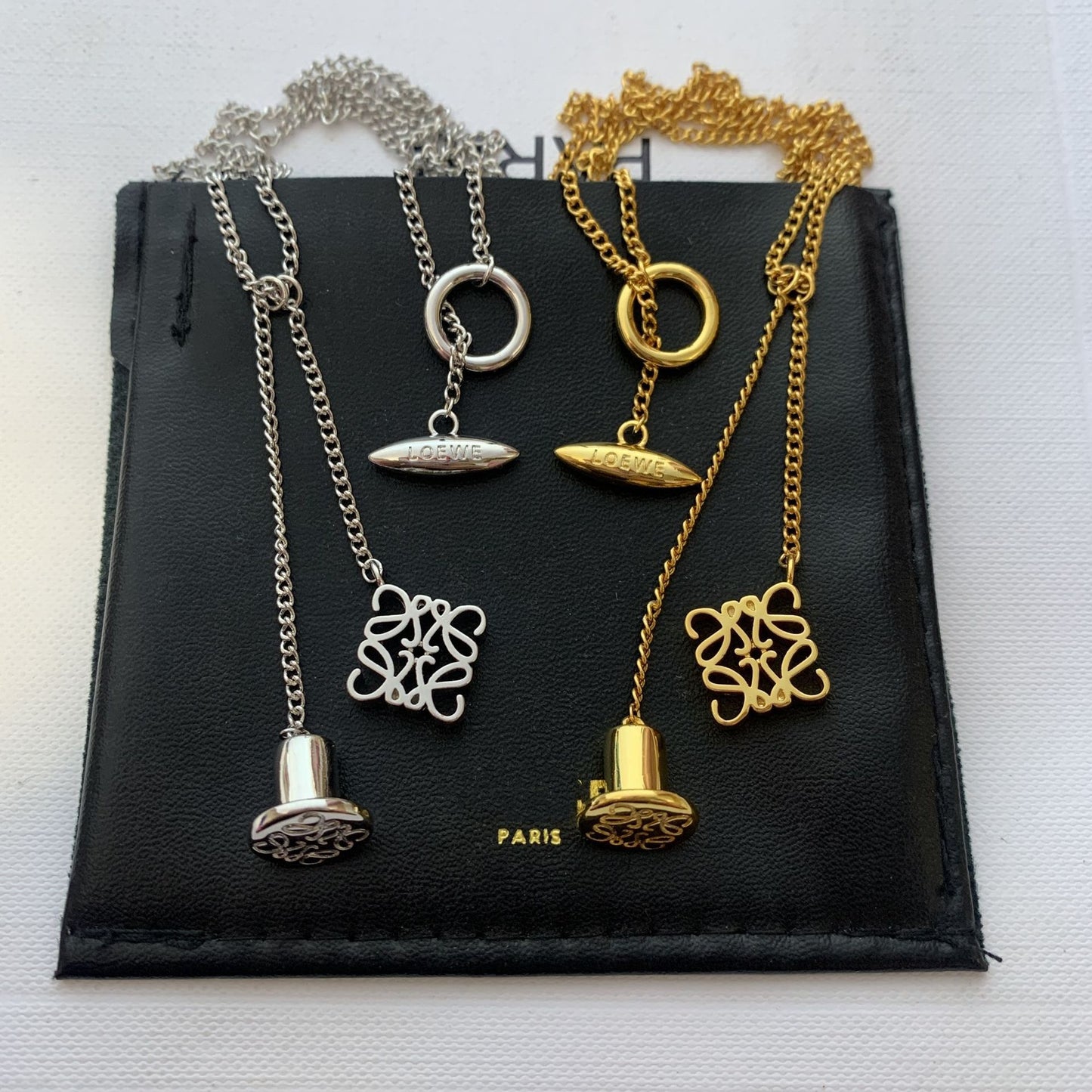  Clean, direct shot of the necklace on a plain background, clearly showcasing the Anagram charm and the fine chain.