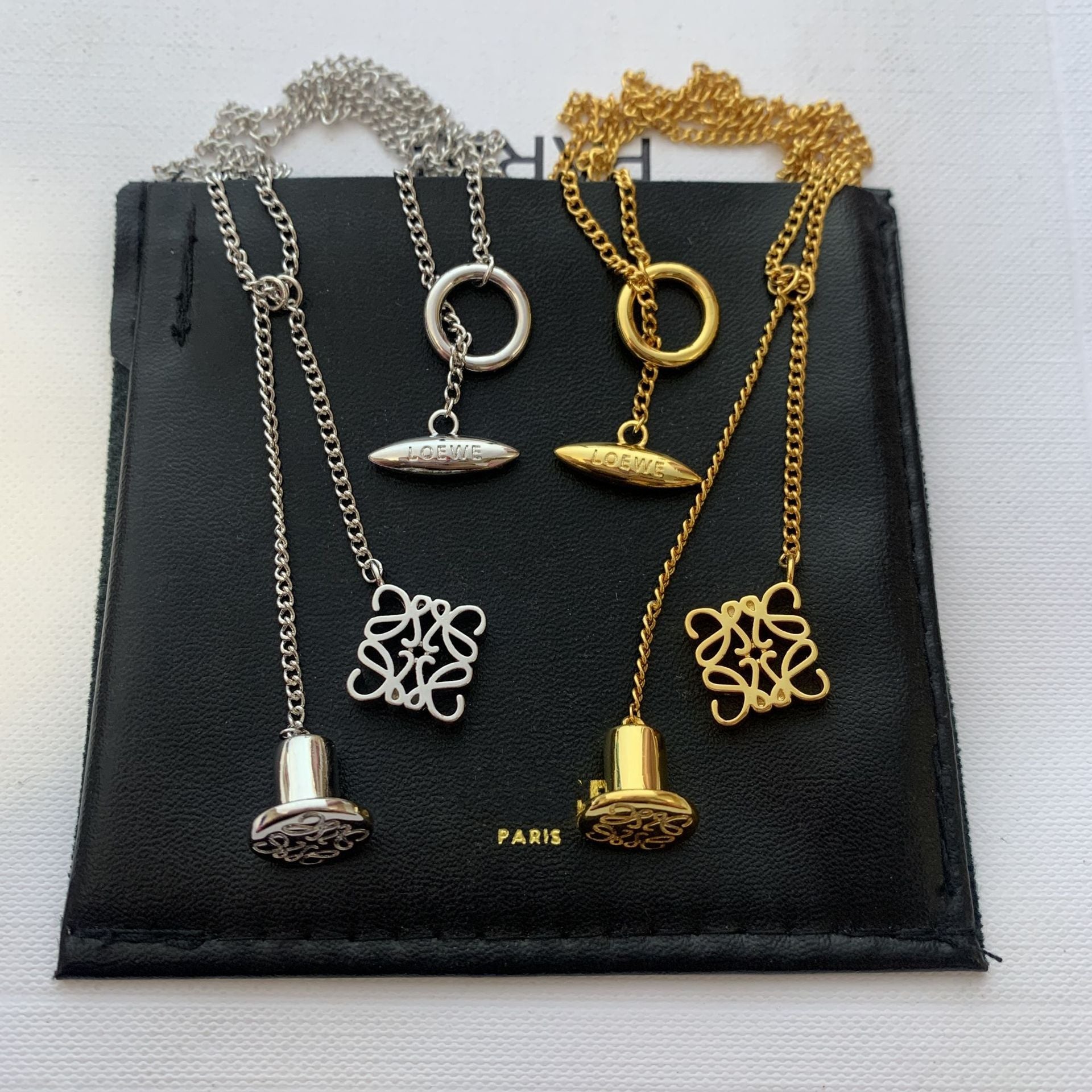  Clean, direct shot of the necklace on a plain background, clearly showcasing the Anagram charm and the fine chain.