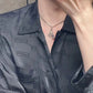  A model with a sleek, modern style wearing the necklace with a simple top, demonstrating its effortless elegance.
