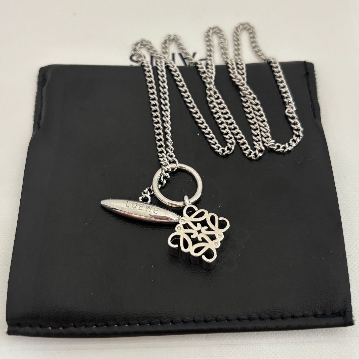  Clean, crisp shot of the necklace laid flat or worn, against a solid neutral background, focusing on the pendant and delicate chain.