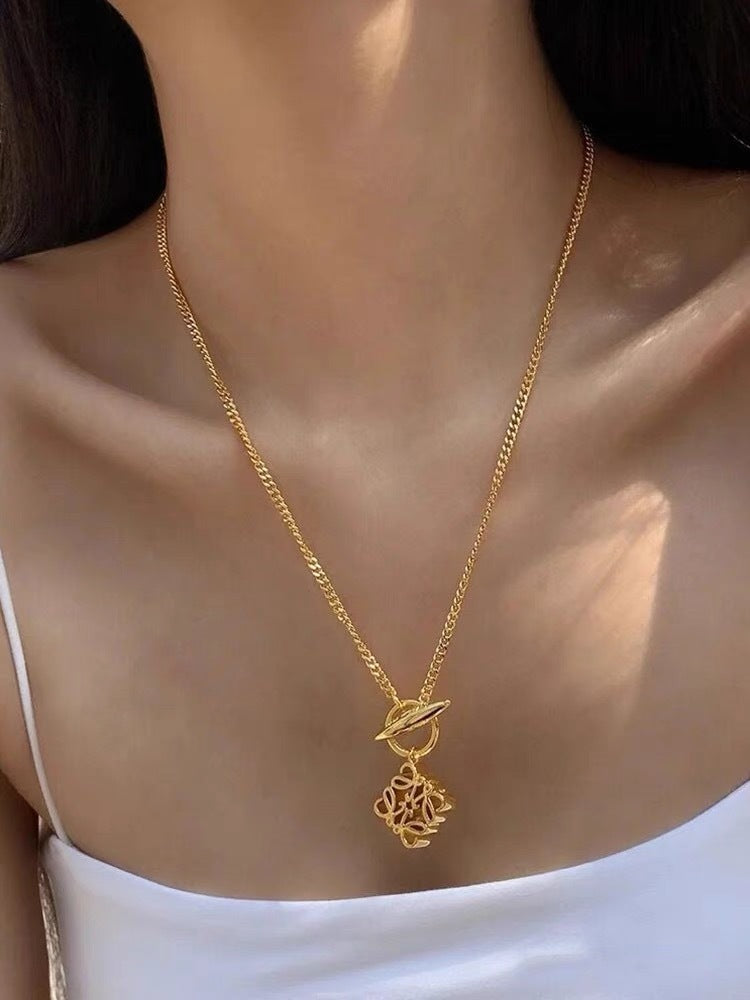  A model with a minimalist aesthetic wearing the necklace over a simple crewneck or blouse, showcasing its understated elegance.
