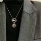  A model with a minimalist aesthetic wearing the necklace over a simple crewneck or blouse, showcasing its understated elegance.