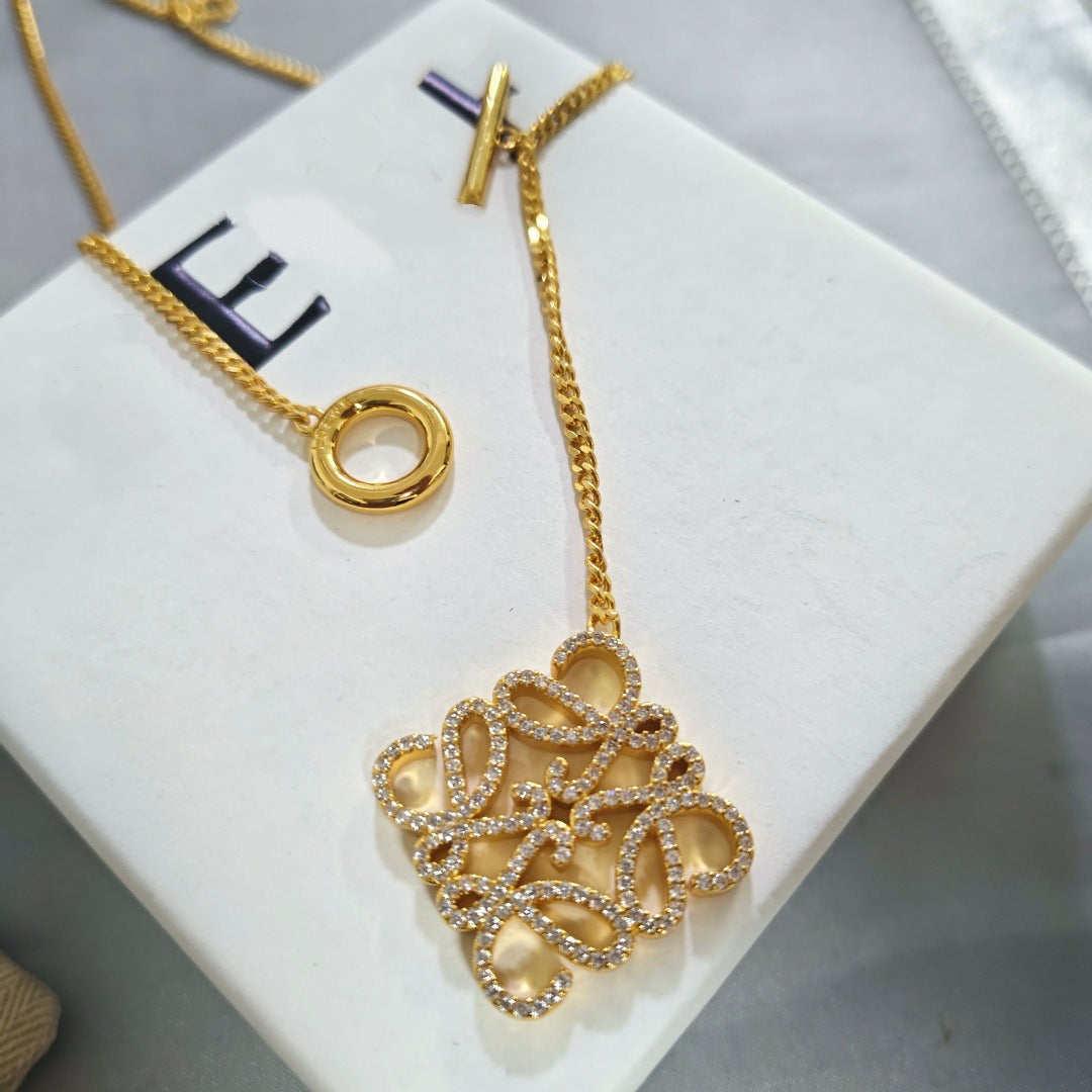 Macro shot tightly focused on the Anagram logo pendant, highlighting the precise interlocking 'L' design and finish.