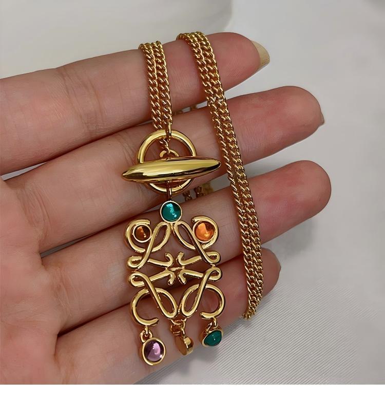 Macro shot tightly focused on the Anagram pendant, showcasing the precise setting and stunning variety of colored stones.