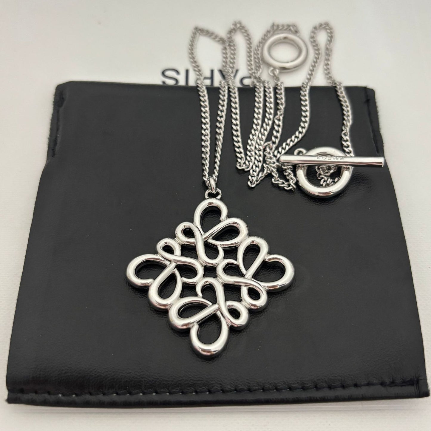 Clean shot of the necklace laid flat or styled in a loose loop, showcasing the pendant and the substantial chain.