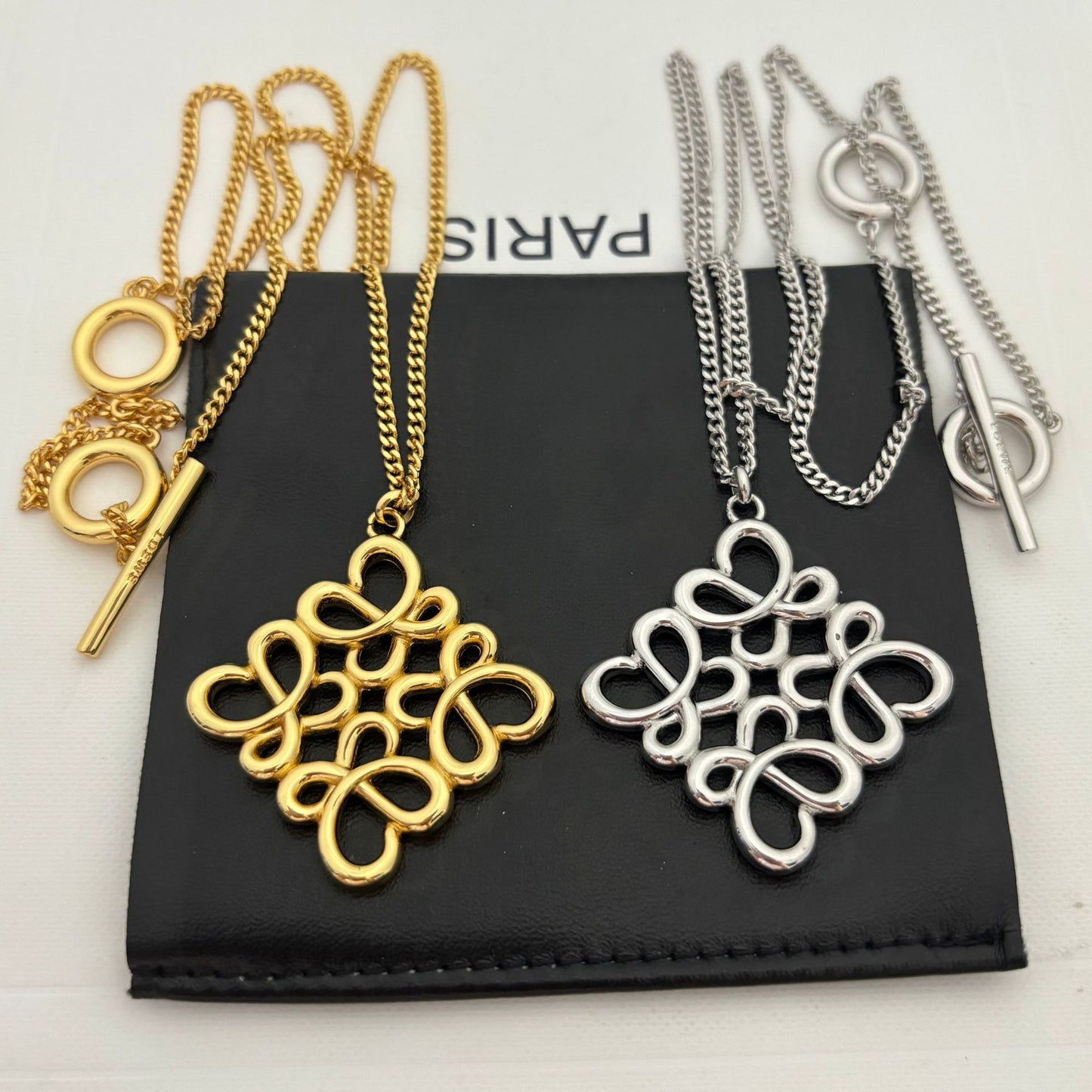 Clean shot of the necklace laid flat or styled in a loose loop, showcasing the pendant and the substantial chain.