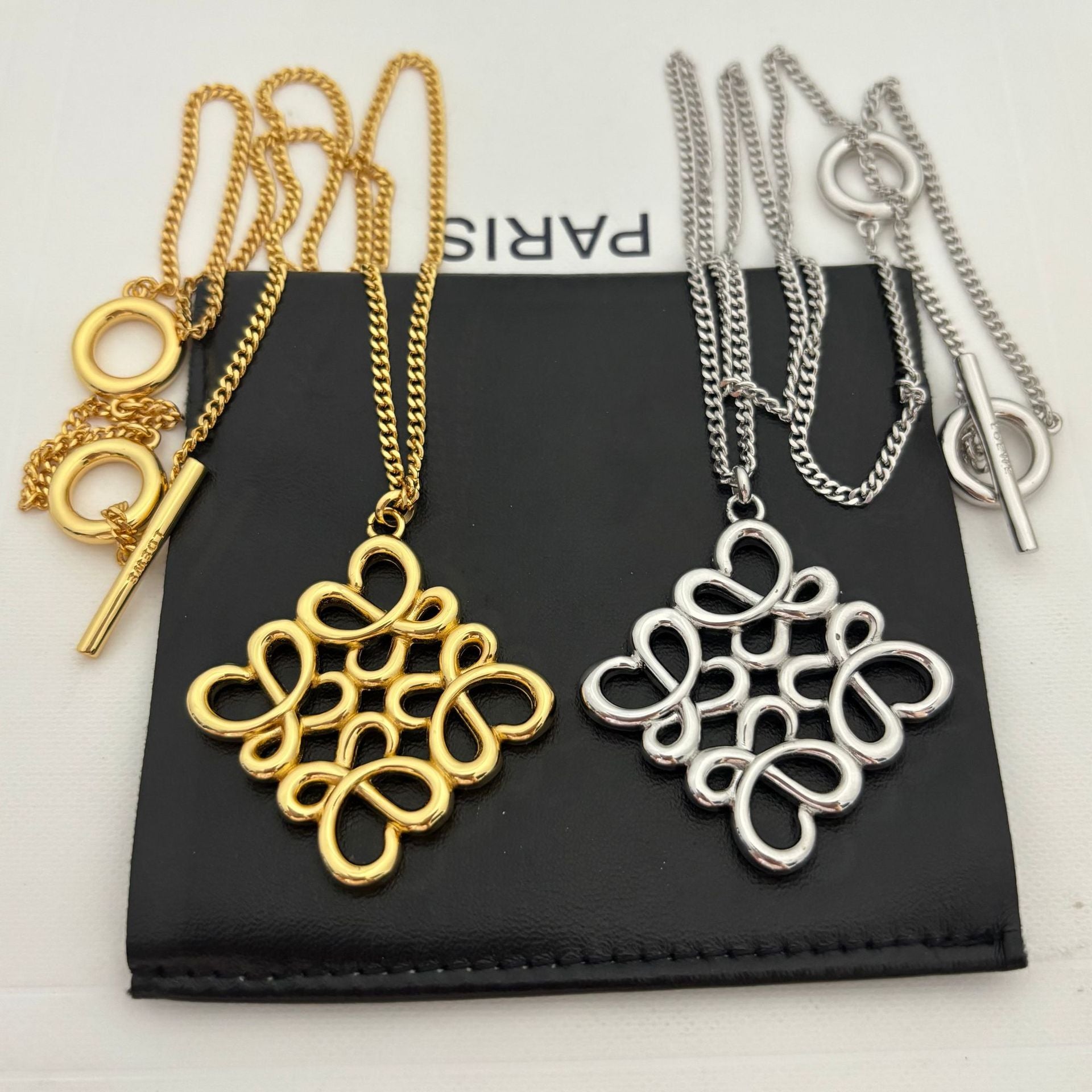 Clean shot of the necklace laid flat or styled in a loose loop, showcasing the pendant and the substantial chain.