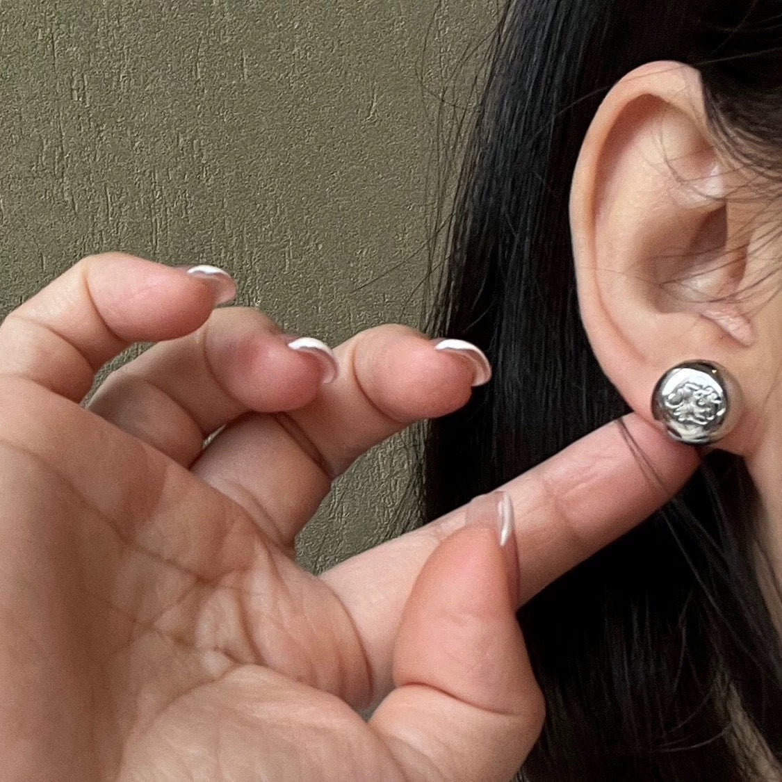  A soft-focus close-up of the earrings being worn, emphasizing their understated, elegant presence on the earlobe.
