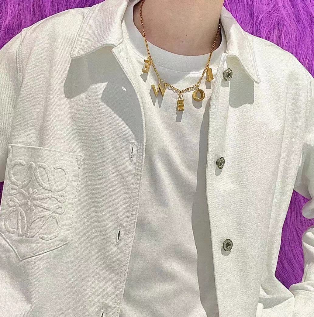  An editorial-style image of a model in minimalist clothing, using the necklace as the powerful, singular focal point.