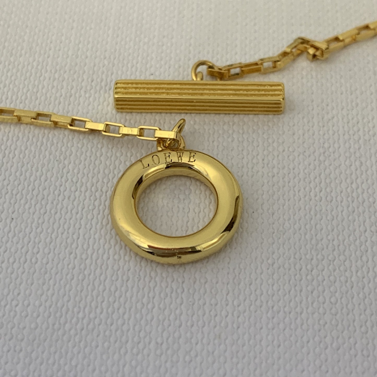  An editorial-style image of a model in minimalist clothing, using the necklace as the powerful, singular focal point.