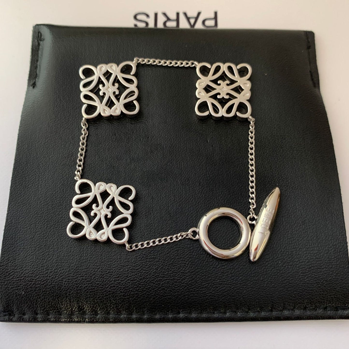 Artistic shot of the bracelet isolated on a stark background, emphasizing its hollow geometric form and architectural lines.