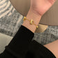 The bracelet displayed on a pedestal or next to a modern sculpture/architectural model, reinforcing its status as a piece of collectible design art.