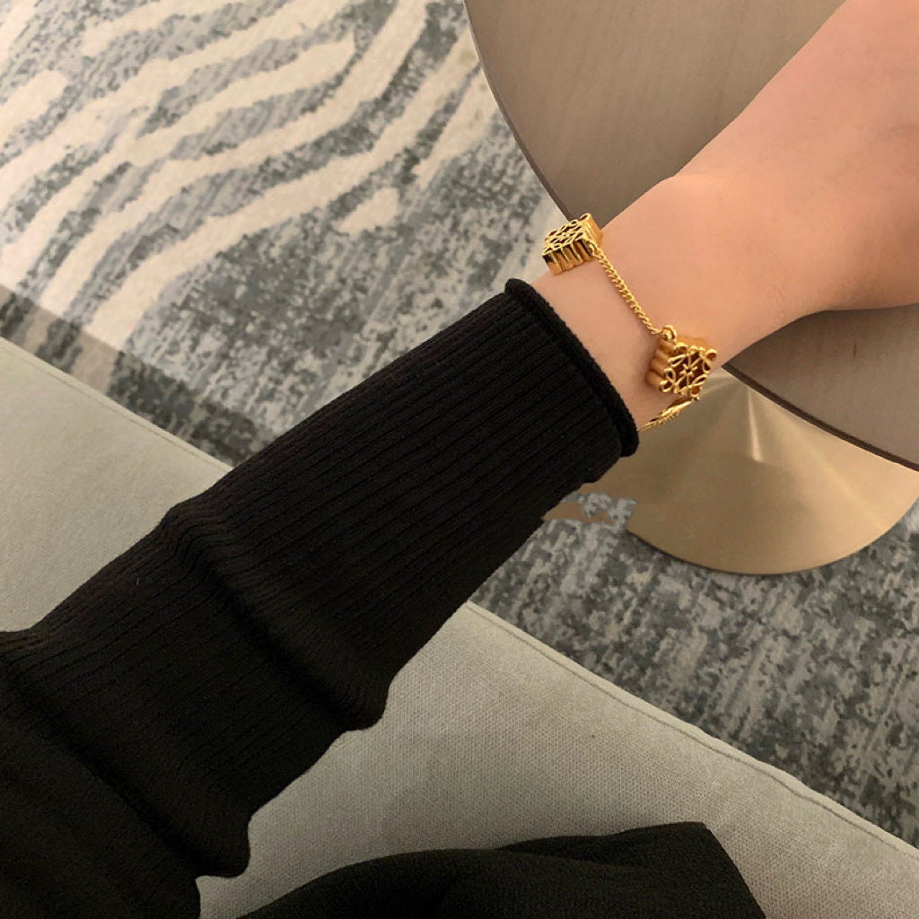 The bracelet displayed on a pedestal or next to a modern sculpture/architectural model, reinforcing its status as a piece of collectible design art.
