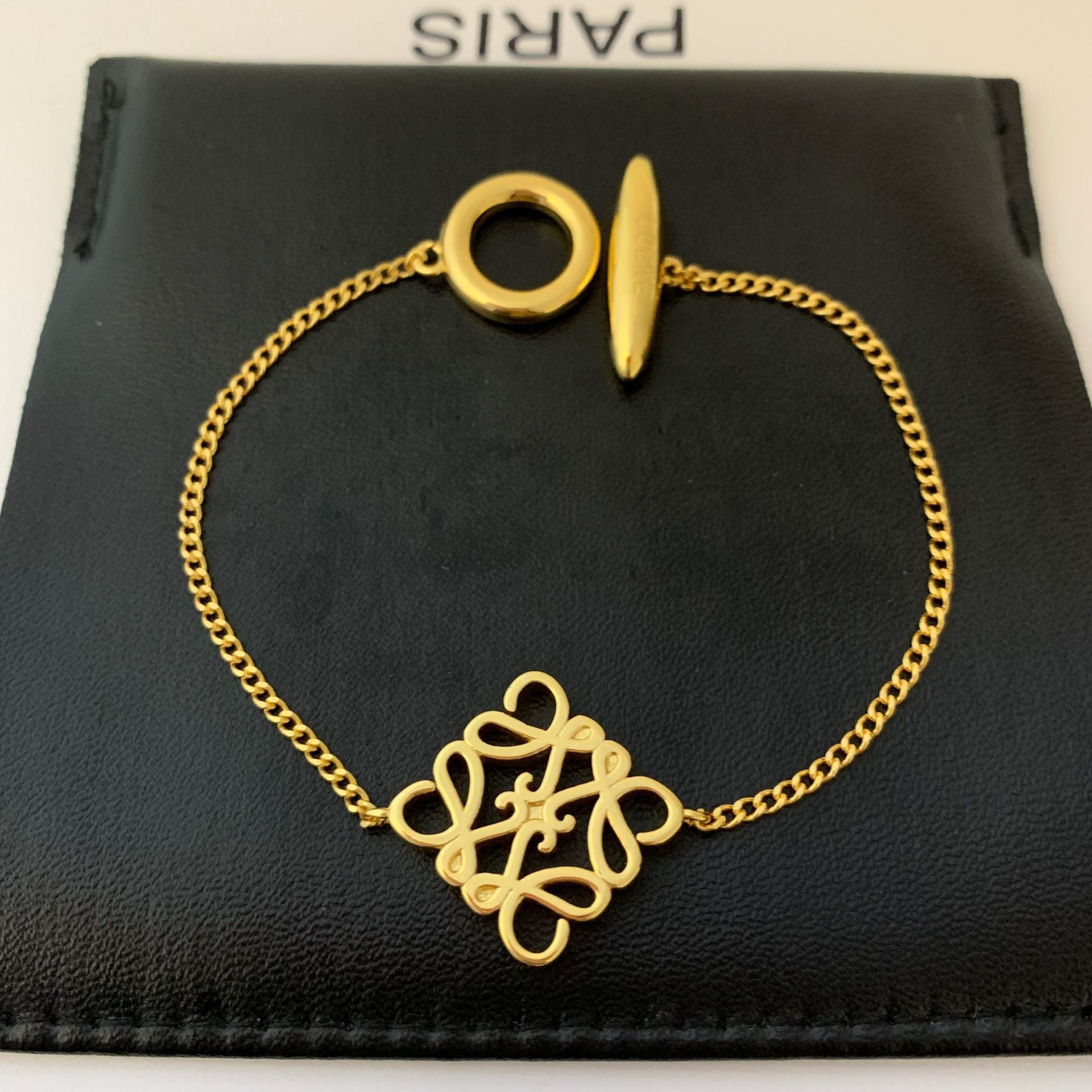 Artistic shot of the bangle isolated on a neutral background, highlighting its unique 3D geometric form and the hollow OT clasp.