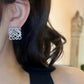 A professional photo of a model wearing the earrings, styled with casual and formal attire to demonstrate versatility. Alt text: "Model Wearing Loewe Gold Geometric Earrings - Elegant Accessory for North American Women."