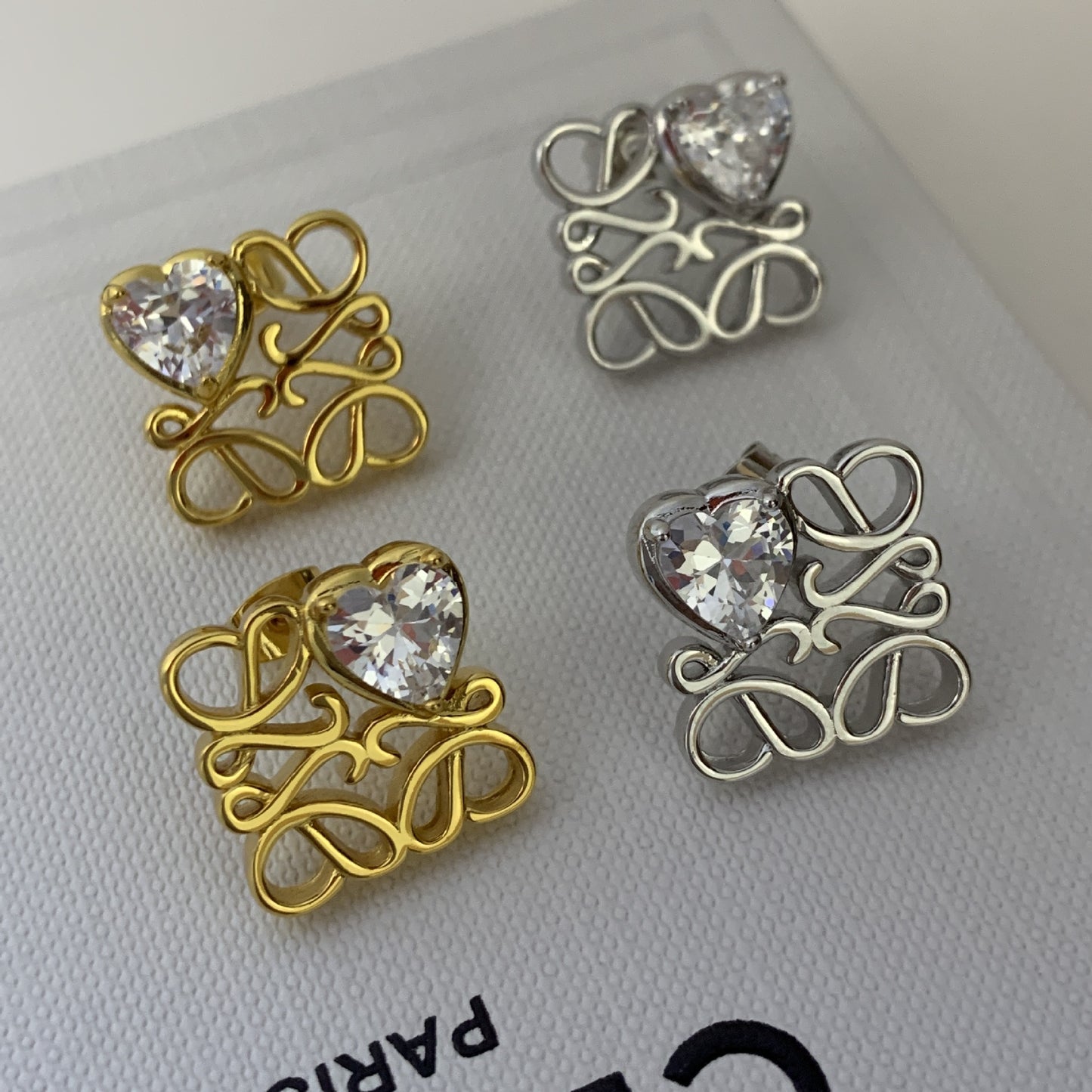 Macro shot tightly focused on the "Loving Heart" motif, highlighting the precise interlocking detail and polished finish.