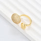 Clean, angled shot of the ring on a finger or stand, showcasing the square silhouette and intricate hollow pattern against a solid background.