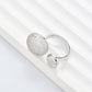 Clean, angled shot of the ring on a finger or stand, showcasing the square silhouette and intricate hollow pattern against a solid background.