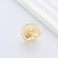 Clean, angled shot of the ring on a finger or stand, showcasing the square silhouette and intricate hollow pattern against a solid background.