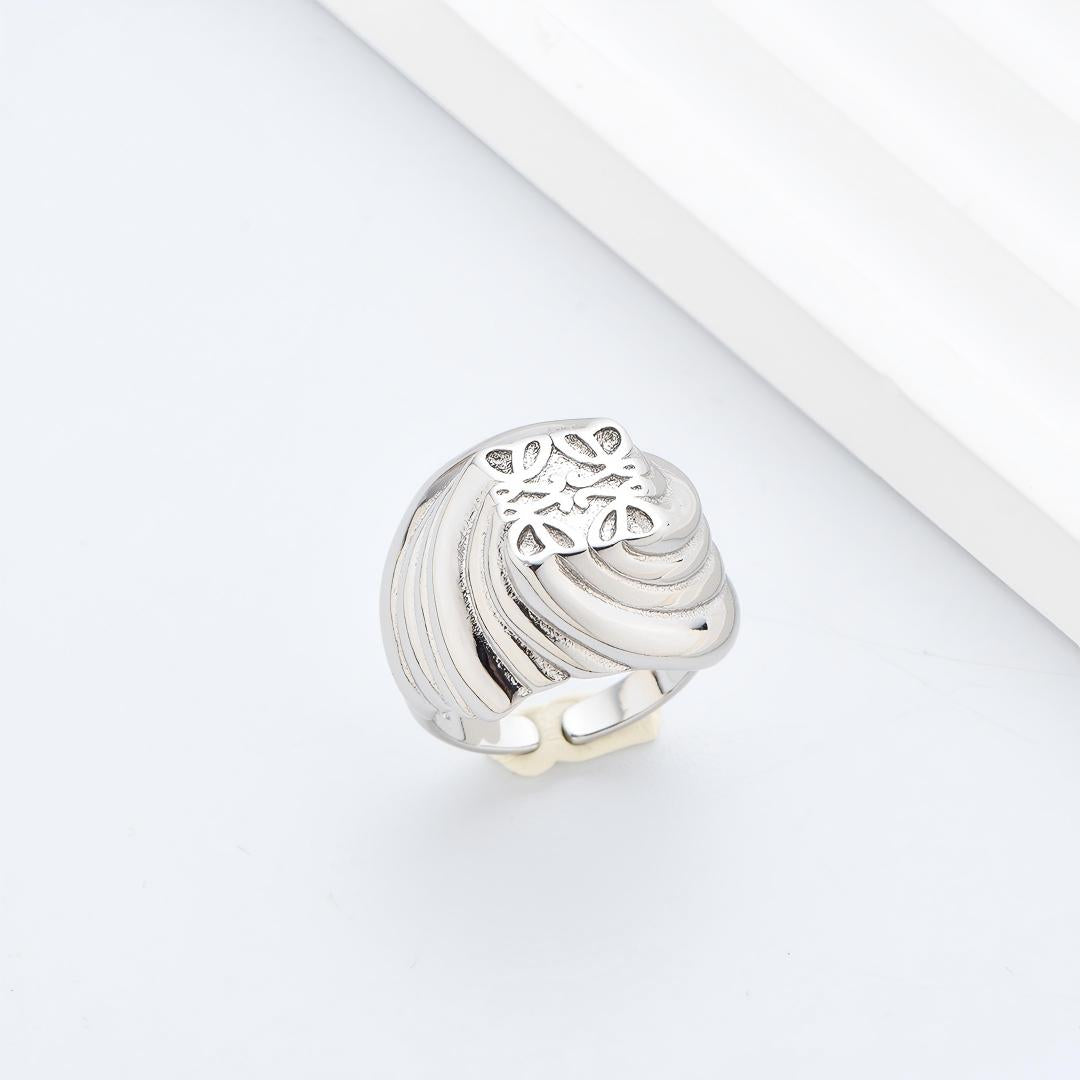 Clean, angled shot of the ring on a finger or stand, showcasing the square silhouette and intricate hollow pattern against a solid background.
