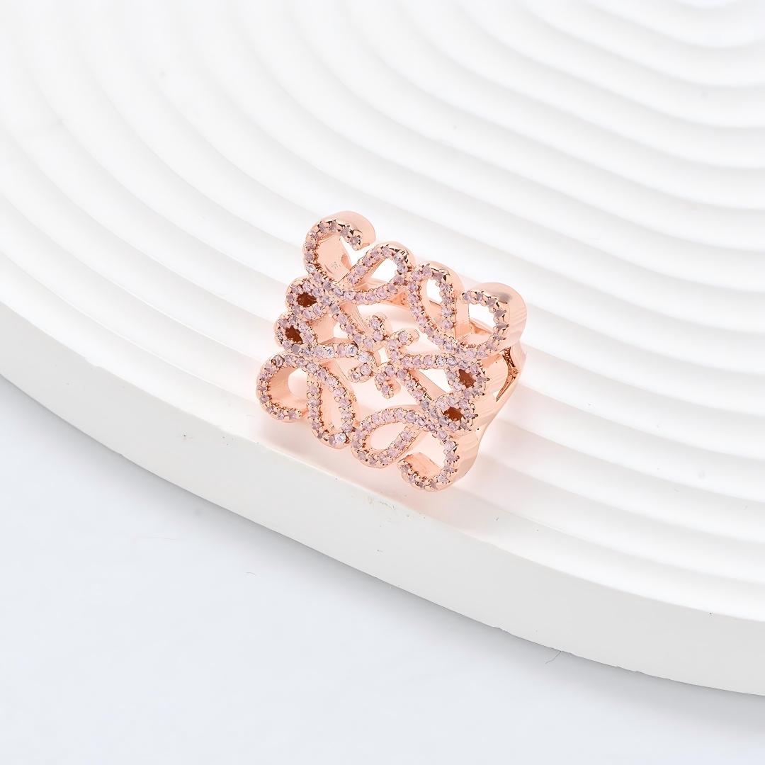Clean, angled shot of the ring on a finger or stand, showcasing the square silhouette and intricate hollow pattern against a solid background.