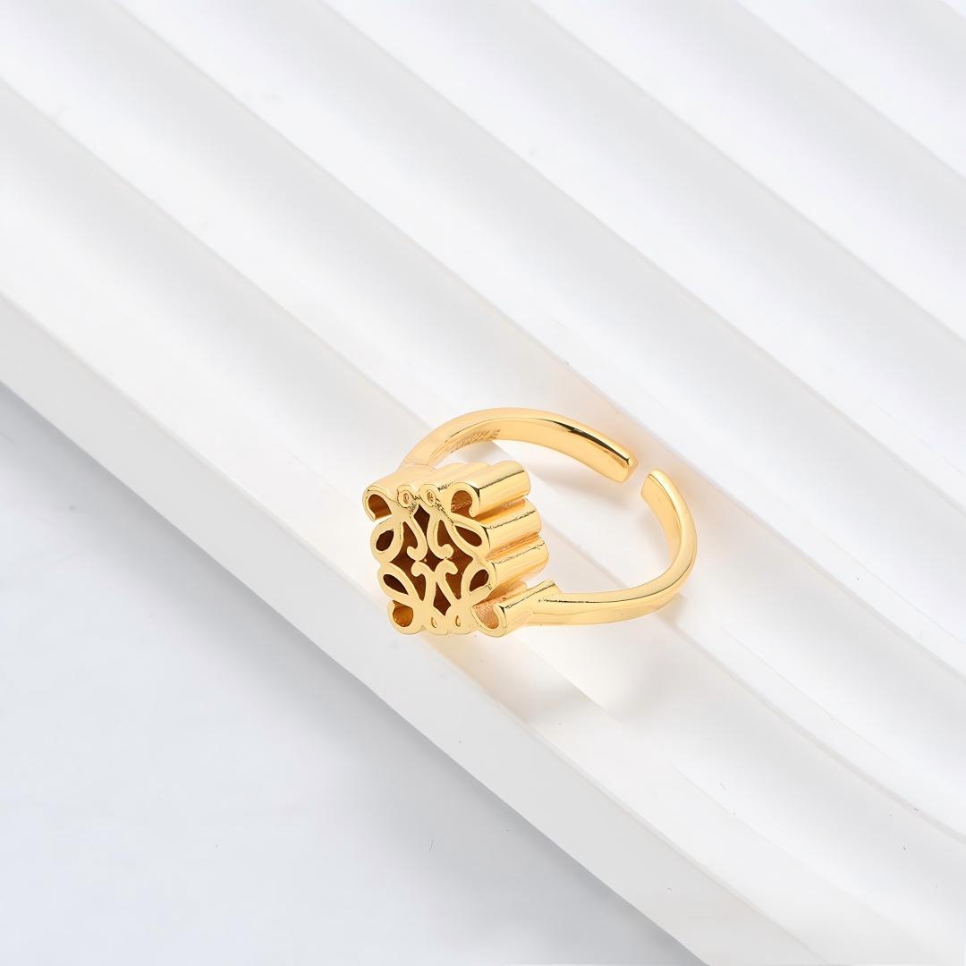 Clean, angled shot of the ring on a finger or stand, showcasing the square silhouette and intricate hollow pattern against a solid background.