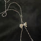 Silver necklace with a bow pendant on a dark background