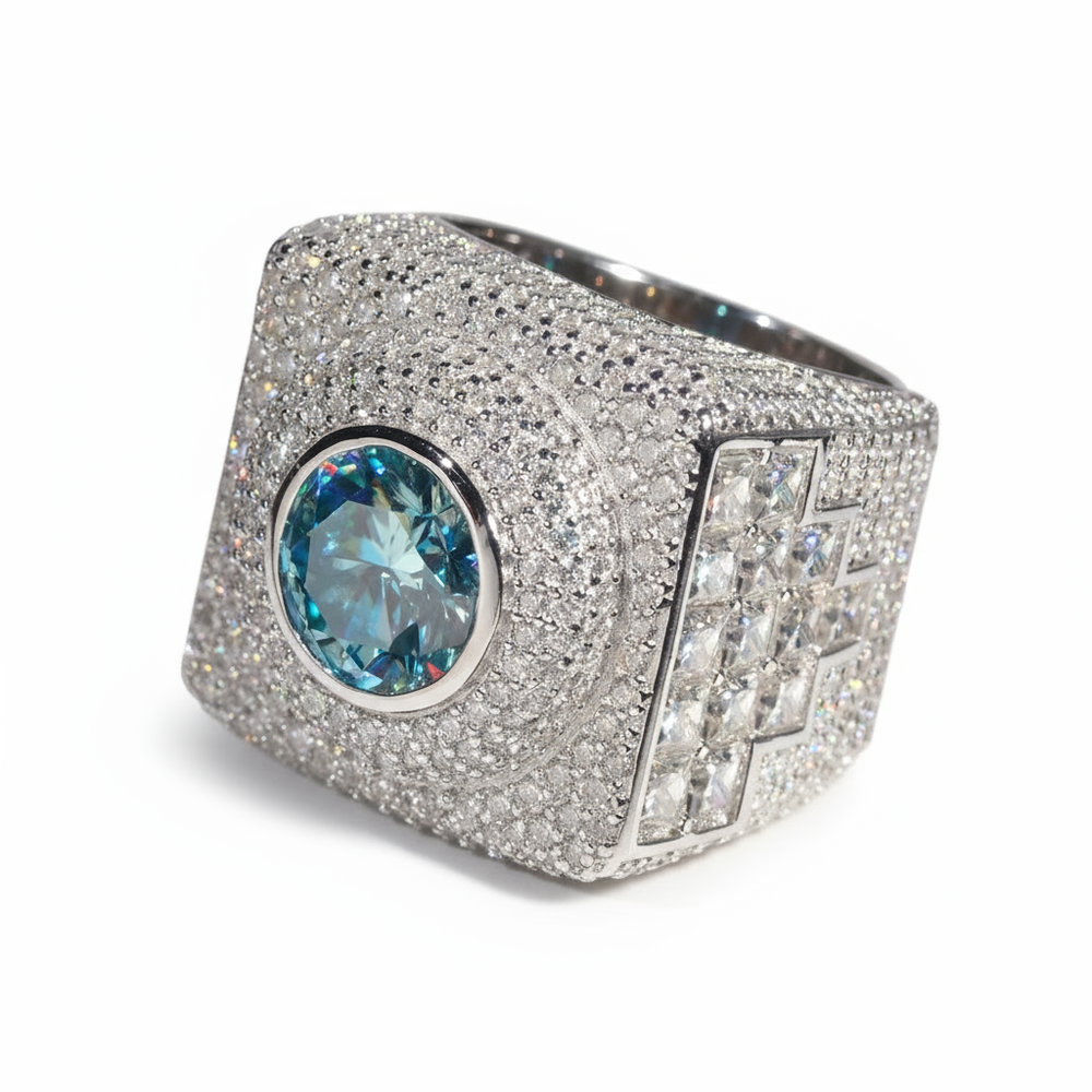 Luxury ring with a large blue gemstone and diamond-studded band on a white background